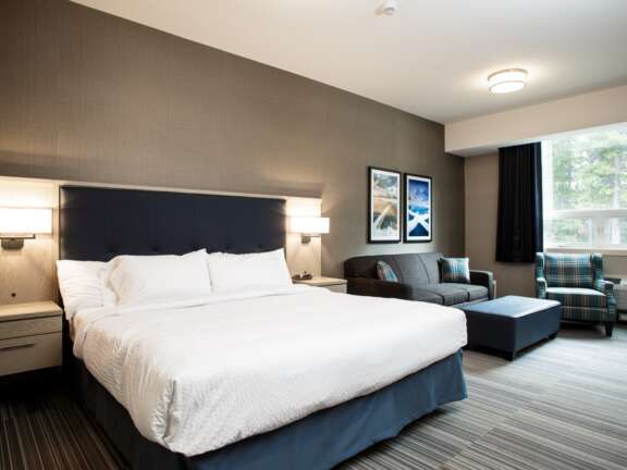 Wheelchair-accessible king room with sofa bed at Mountaineer Lodge, Lake Louise, step-free access, sleeps four.