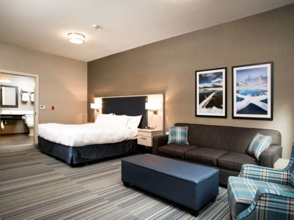 Wheelchair-accessible king room with sofa bed at Mountaineer Lodge, Lake Louise, step-free access, sleeps four.