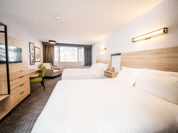 Two queen beds in the Main Lodge at Mountaineer Lodge, Lake Louise, near the hot tub and lounge.