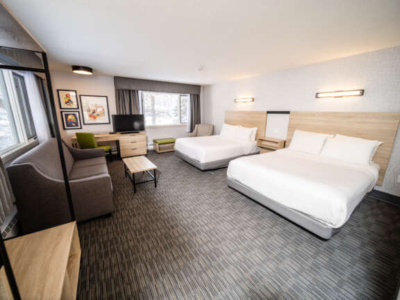 Family room with two queens and a sofa bed at Mountaineer Lodge, Lake Louise, sleeps six across Main Lodge and Timber Building.