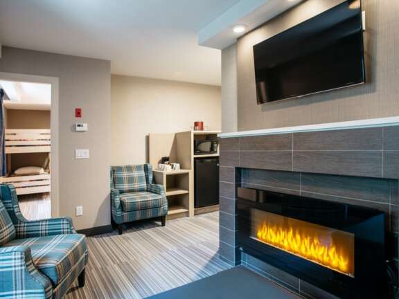 Fireplace view in the family suite with bunk beds at Mountaineer Lodge, Lake Louise, queen bed and sofa bed, sleeps six.