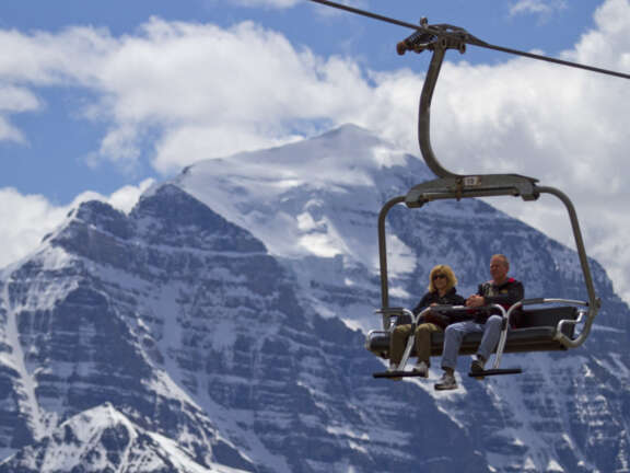 Two people riding the Summer Lake Louise Sightseeing Gondola