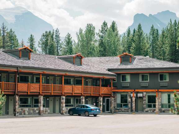 A hotel named the Mountaineer Lodge, showing the Timber Building below Mount Temple in Lake Louise.
