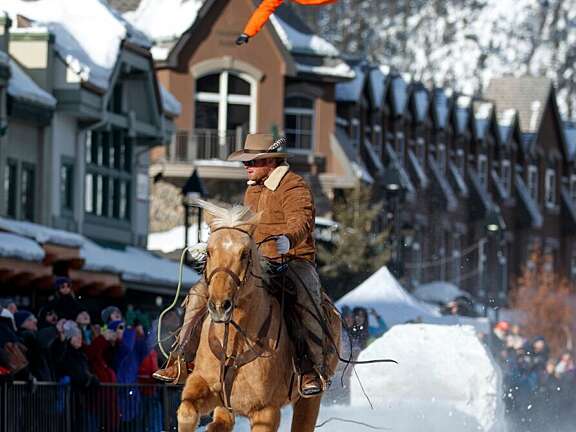 Winter festival skijoring in downtown Banff, paired with a cozy winter stay at Mountaineer Lodge in Lake Louise.