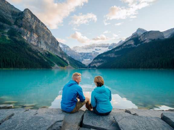 A couple enjoying the majestic glacial waters of Lake Louise, Alberta.