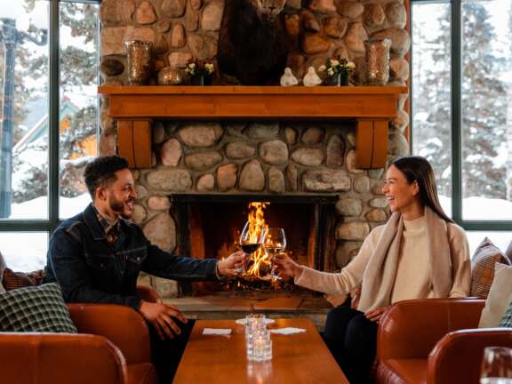 Guests enjoying a glass of wine at the Outpost Pub in Lake Louise, Alberta.